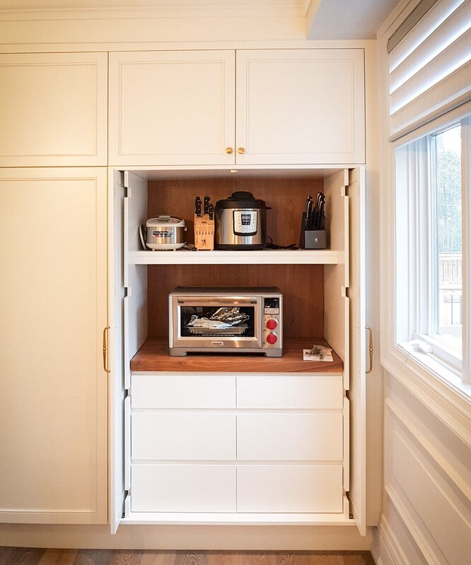 Kitchen appliance cupboard with open-and-slide-back doors and walnut accent finish