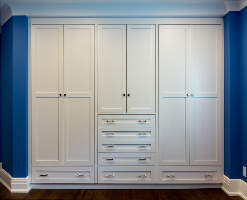 Bedroom closet in white lacquered finish on shaker doors