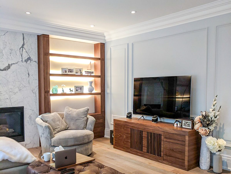 Walnut shelving on either side of fireplace with matching media cabinet