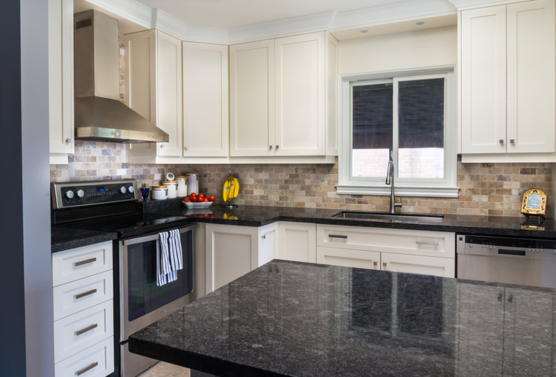 White shaker kitchen with dark granite counters
