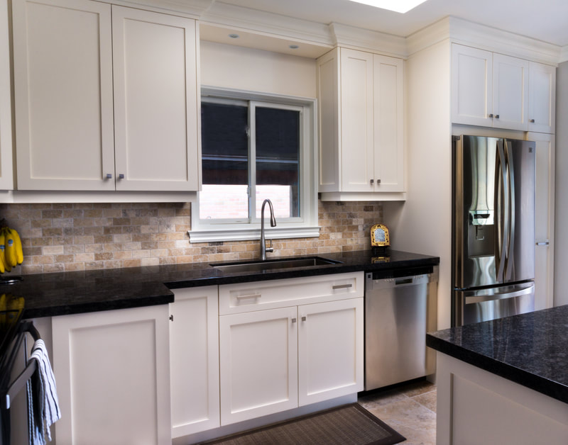 White shaker kitchen with dark granite counters